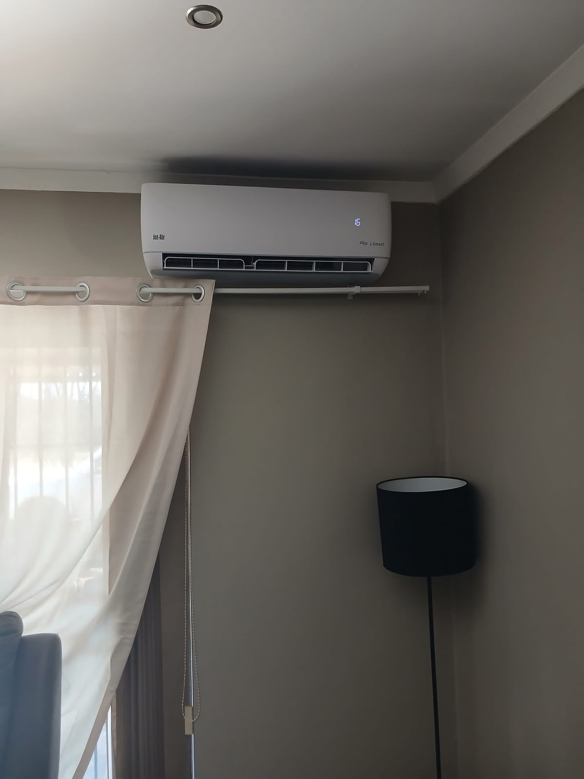 Indoor air conditioner installed beside bedroom curtains in Gauteng