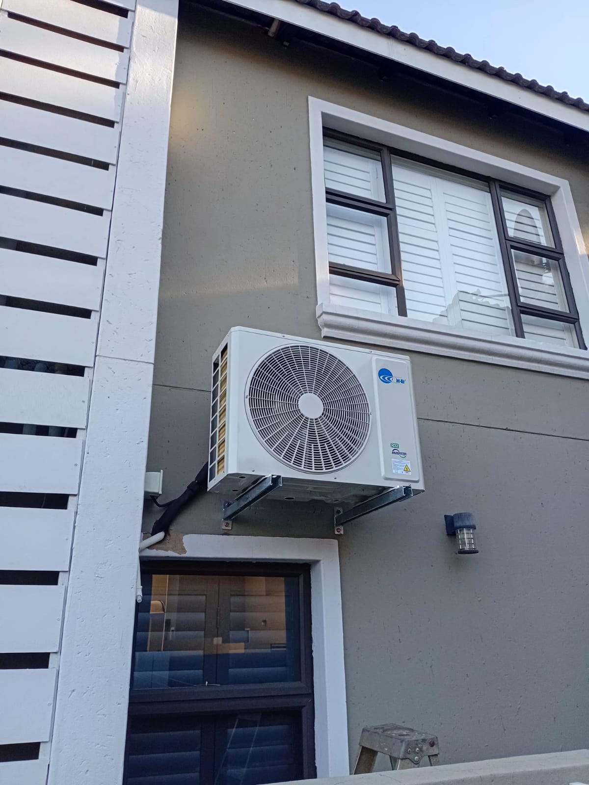 Outdoor condenser installation beside an upstairs window in Gauteng